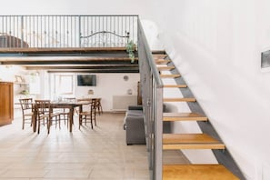 A modern interior with a dining area, a staircase, and a living space.