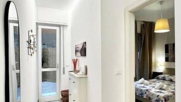 A modern room with a bed, a desk, and a mirror. - Hostdomus - Garden Suite (Finale Ligure)