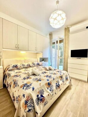 Una camera da letto con un letto, una TV e una finestra.