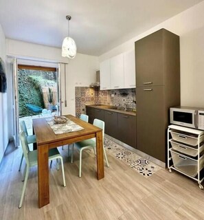 Una cucina compatta con zona pranzo, un forno a microonde e un piccolo armadietto.