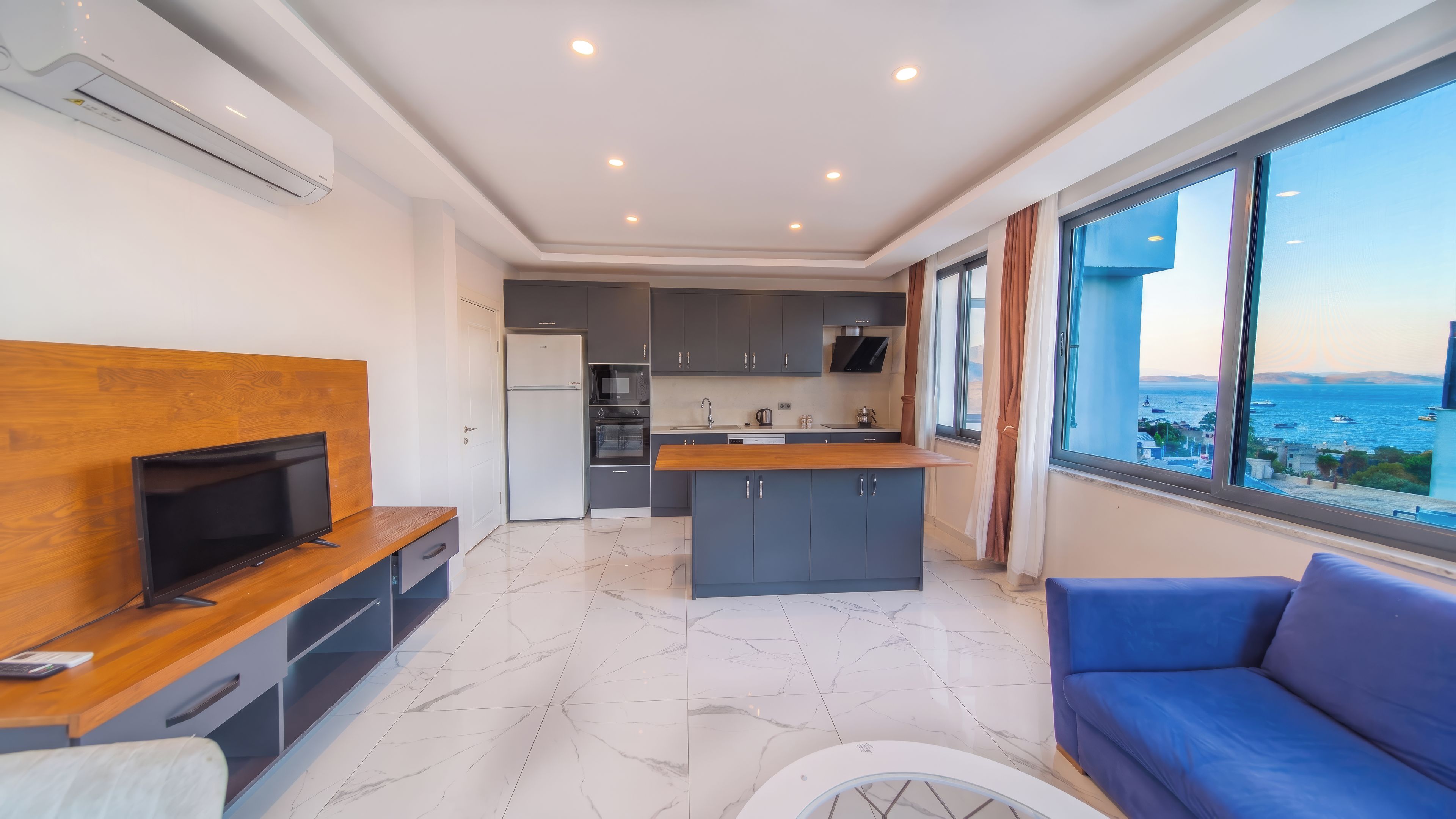 A modern apartment with a kitchen, dining area, and a large window with a view.