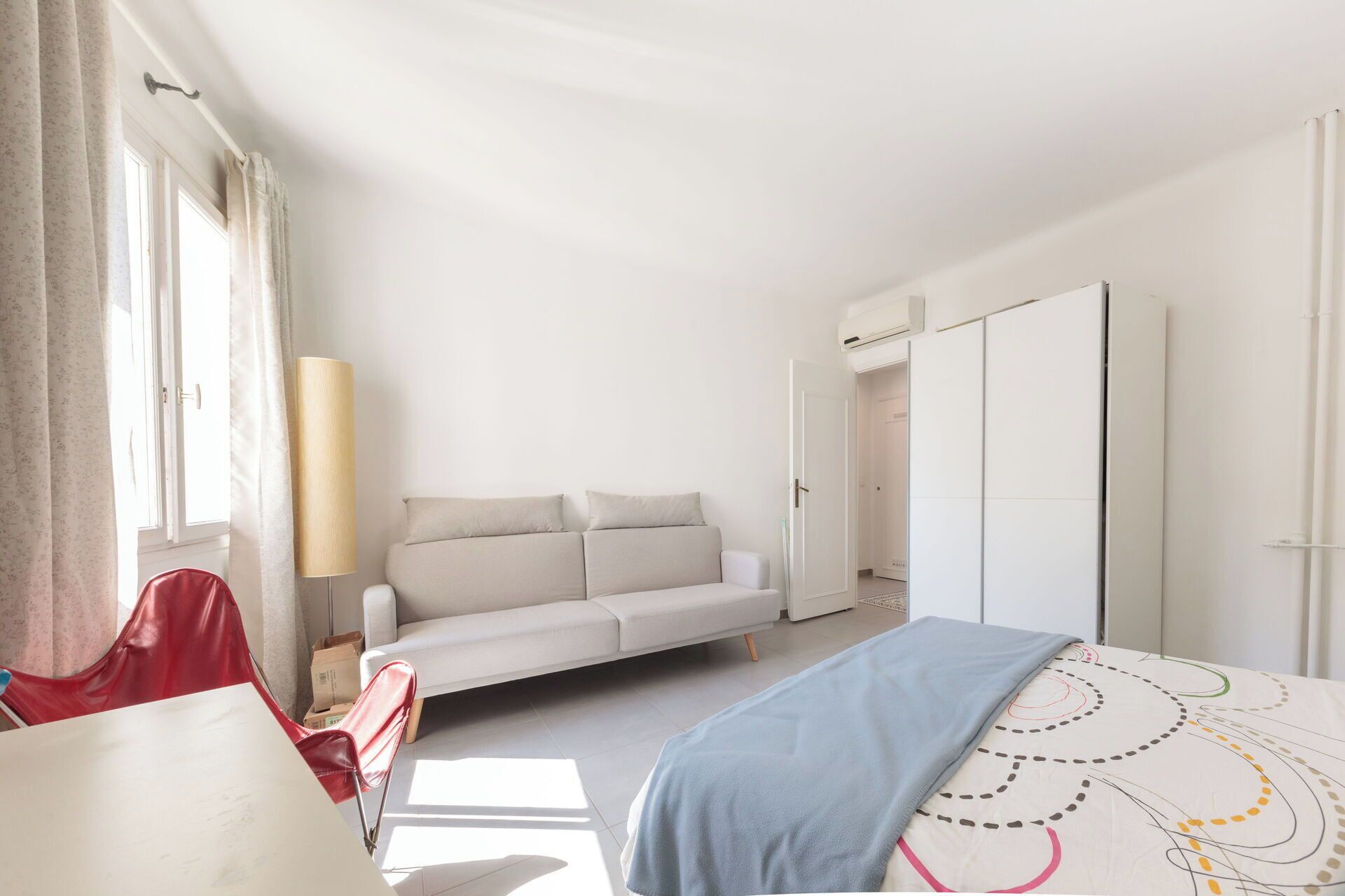 Une chambre à coucher comprenant un lit, un canapé, un bureau et une armoire.