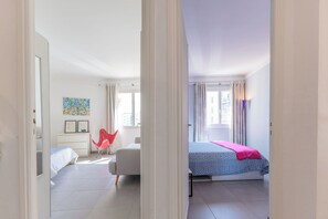 Ein Schlafzimmer mit Bett, Stuhl, Schreibtisch und Fenster.