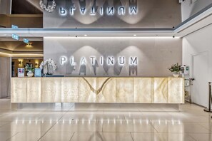 Ein Empfangsschalter mit der Beschilderung 'PLATINUM', einer Marmorplatte und einem modernen Innenarchitekturdesign.