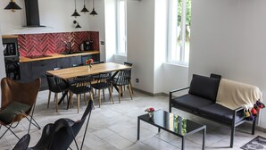 Ein modernes Wohnzimmer mit einer Couch, Esstisch, Stühlen und einem Couchtisch.