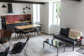 Ein modernes Wohnzimmer mit einer Couch, Esstisch, Stühlen und einem Couchtisch.