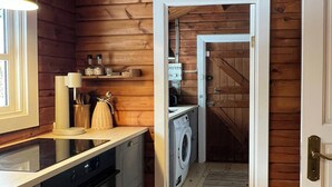 Keittiössä on puuseinät, pesukone ja liesi.
