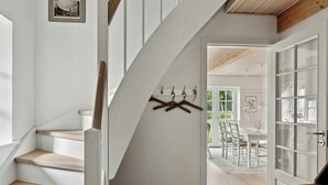 A staircase with wooden steps and a coat rack with hangers. - Guest house by lake and forest (Nakskov)