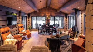 A spacious living area with a wooden ceiling, large windows, and modern furniture. - Cabin with great fishing at Trysilfjellet (Jordet)