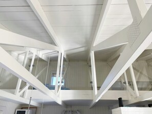 A modern interior with white walls and ceiling, geometric ceiling beams, and a visible window. - Personality in architect home near Spøttrup (Spøttrup)