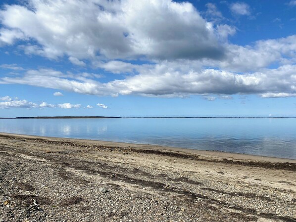 A calm lake with a pebbly shore and distant land under a partly cloudy sky. - Personality in architect home near Spøttrup (Spøttrup)