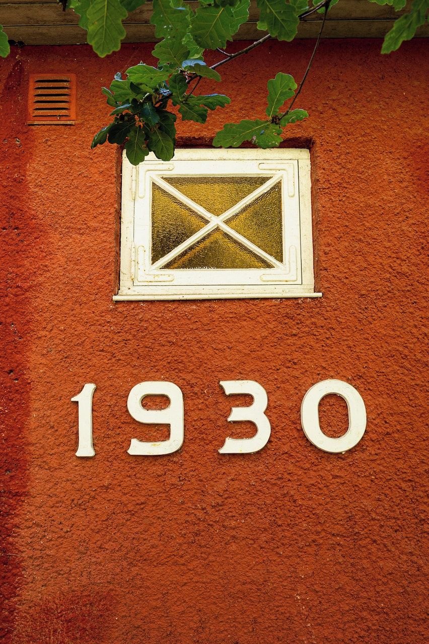 Une façade d’immeuble avec une fenêtre et le chiffre « 1930 » affiché en évidence.