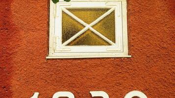 Une façade d’immeuble avec une fenêtre et le chiffre « 1930 » affiché en évidence.