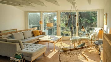 Uma sala de estar espaçosa com sofá, mesa de centro e rede.