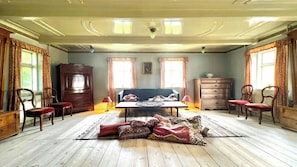 A room with a wooden floor, a sofa, a table, and a cabinet.