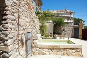 Ein Steinhaus mit Innenhof, Außenbereich und einem kleinen Pool.