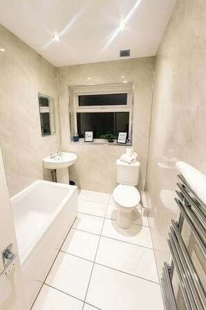 A modern bathroom with a bathtub, toilet, and sink. - Comfortable 3BR Sleeps 6 | Contractor Stays (Flintshire)
