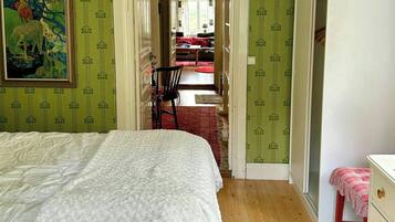 Een slaapkamer met een bed, een stoel, een tafeltje en een kledingkast.