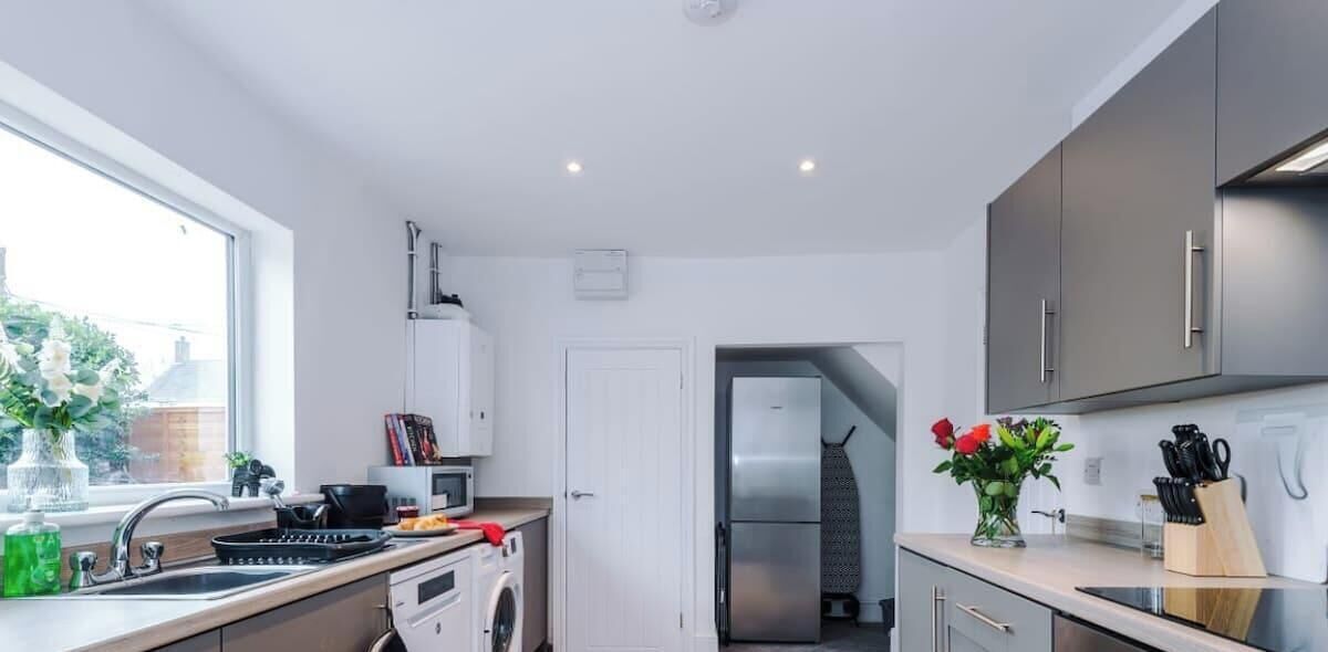 Een moderne keuken met een roestvrijstalen koelkast, een wasmachine en een spoelbak.