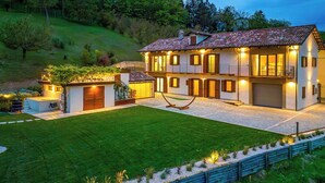 Una casa grande con un patio amplio, una piscina y un césped bien cuidado.