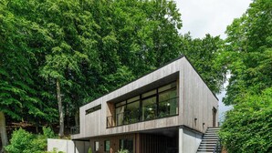 A modern two-story house with a large window, a staircase, and a car parked in front. - Designer villa in Laven near Himmelbjerget (Silkeborg)