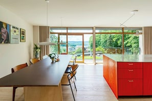 Eine moderne Küche mit einer großen Kochinsel, einem Holzespeisetisch und Stühlen.