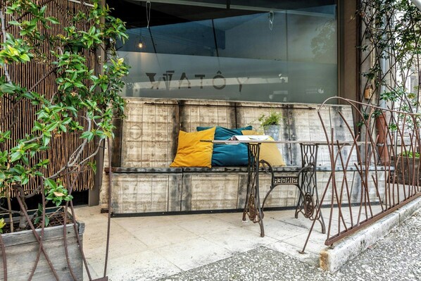 A seating area with a bench, cushions, and a small table.