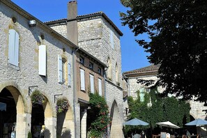 Un bâtiment historique en pierre, doté de fenêtres en arc de cercle et d’un clocher.