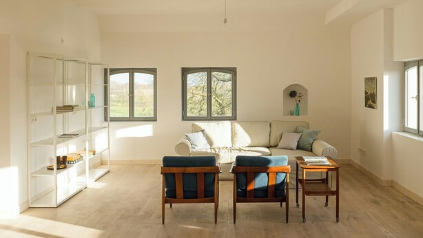A spacious living room with a sofa, two armchairs, a coffee table, and a bookshelf. - Spacious holiday apartment on Rügen (Poseritz)