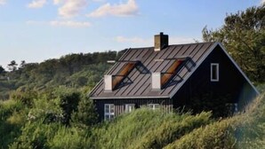 A house with a sloped roof, skylights, and a chimney. - "Lærkehuset" right by Kalundborg Fjord (Kalundborg)