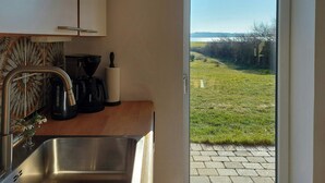 A kitchen with a stainless steel sink, a coffee maker, and a roll of paper towels. - Peaceful summer house near Limfjorden (Nykøbing Mors)