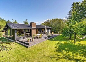 A modern house with a deck, outdoor furniture, and a hammock. - Architect-designed 1960s house near Svinkløv (Fjerritslev)