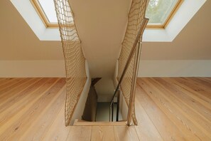 Eine Holztreppe mit Oberlicht darüber, die zu einer Ebene weiter unten führt.