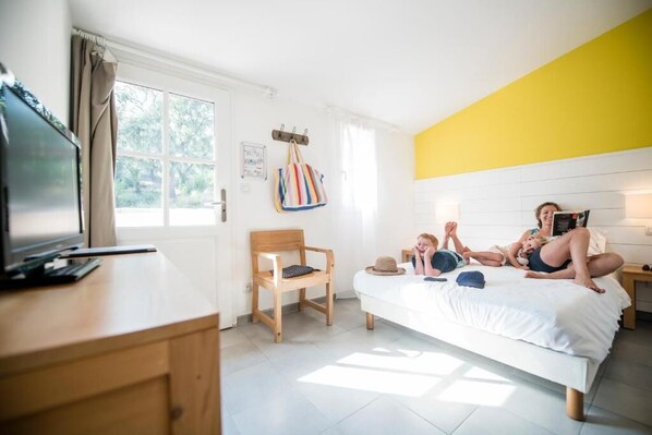 A bedroom with a bed, a desk, a chair, a television, and a window. - Village Club du Soleil - Le Reverdi (Plan-de-la-Tour)