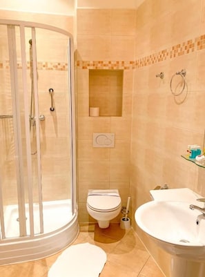 A bathroom with a glass-enclosed shower, a toilet, and a sink. - Hotel Patria (Zakopane)
