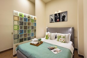 A hotel room with a bed, a wall of decorative glass panels, and a framed artwork above the bed. - Stay Inn on Saryan Street 33 (Yerevan)