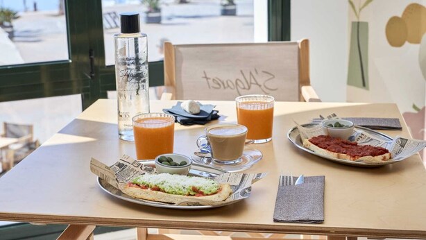 A table with a meal, drinks, and a bottle of water.