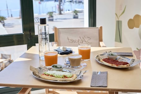 Ein Tisch mit Mahlzeit, Getränken und einer Wasserflasche.. Hotel S'algaret