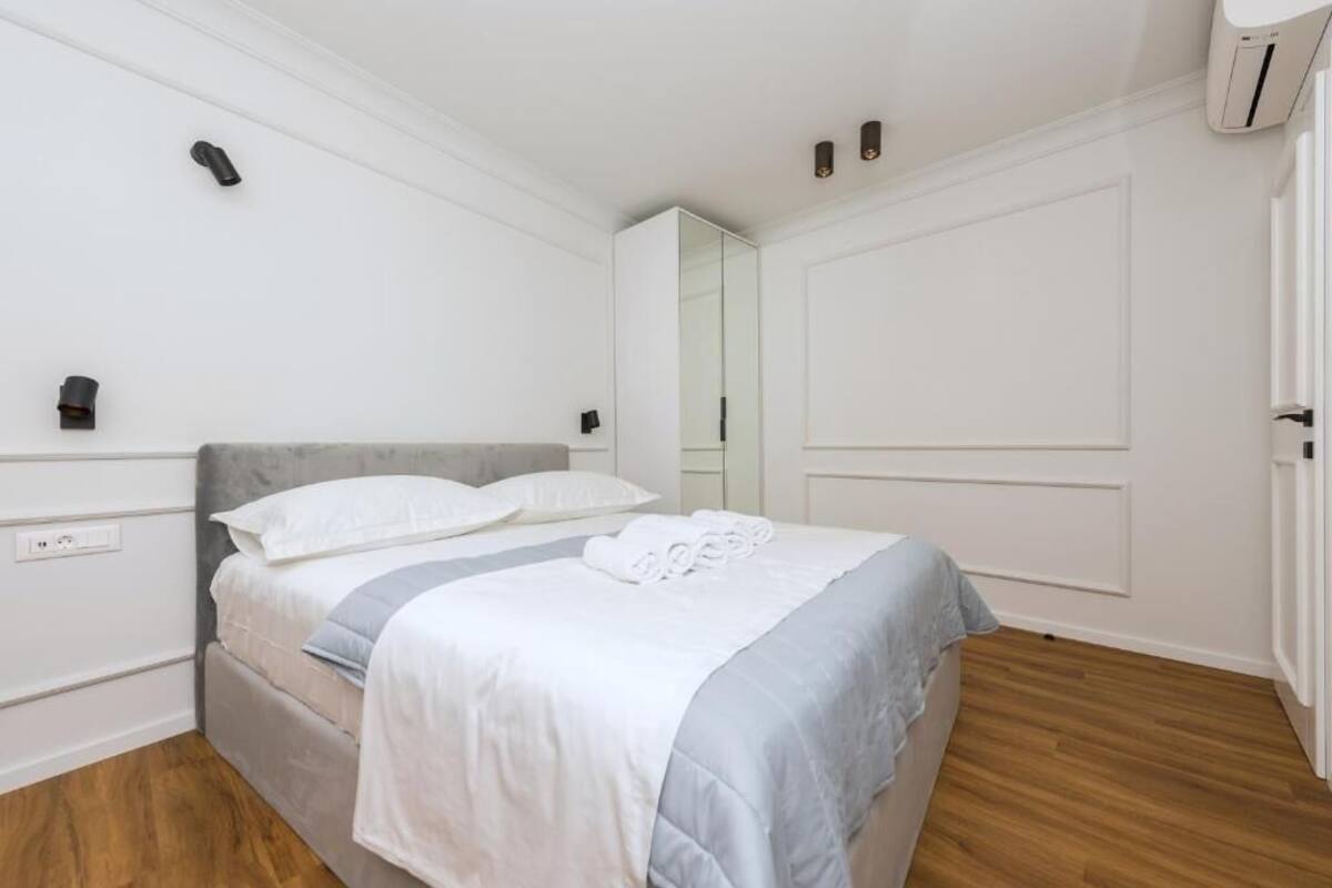 A bedroom with a bed, a wardrobe, and a mirror.
