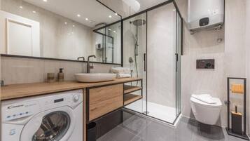 Design appartement | Badkamer | Een haardroger, handdoeken, zeep, shampoo