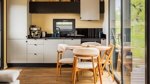 Una cocina moderna con comedor, ventanas amplias y vistas al exterior.