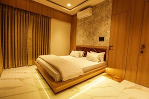 A bedroom with a bed, curtains, an air conditioning unit, and a wardrobe.