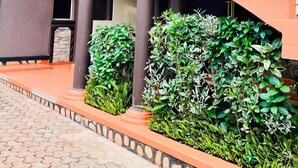 A multi-story building with a central staircase, columns, and a balcony with ornate railings. - Lillian Imperial Country Hotel (Kamuli)