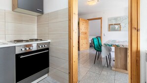A modern kitchen with a stove, oven, and wooden cabinets. - Apartment 'Gemütliche' with Wi-Fi (Göppingen)