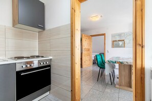 Eine moderne Küche mit Herd, Backofen und Holzschränken.