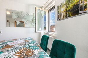 Un salón de conferencias con un mapa del mundo, una ventana con vistas a árboles y una mesa con mantel floral.