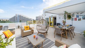 A rooftop terrace with outdoor seating, a dining area, and a view of the cityscape. - Mar & Sol Penthouse Portimão with Sea View, Wi-Fi, and Air Conditioning (Portimão)