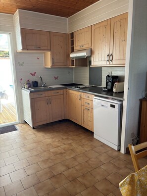 A kitchen with wooden cabinets, a dishwasher, a coffee maker, and a toaster. - Seaside (La Tranche-sur-Mer)