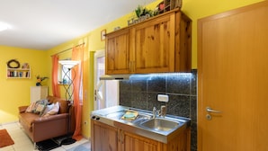 A compact kitchen with wooden cabinets, a sink, and a countertop.