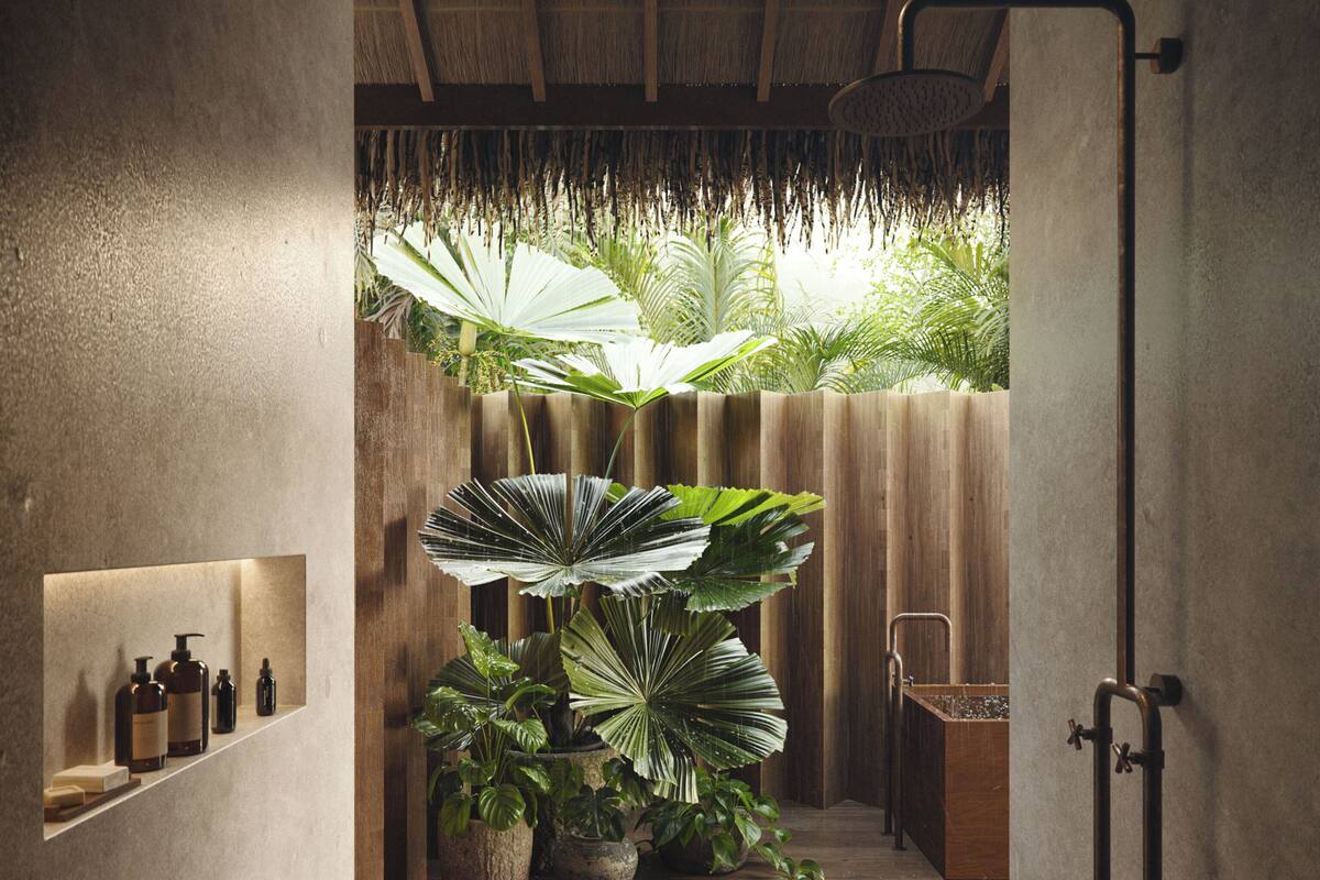 Un baño moderno con suelo de madera, zona de ducha y estante con artículos de aseo.